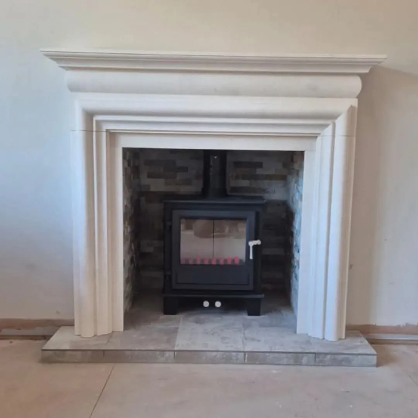 Stove set in a stone fireplace surround