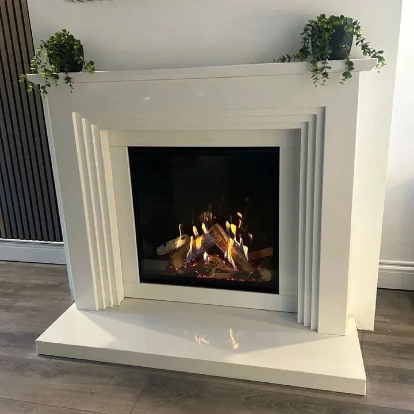 Gas fire in a white fireplace surround