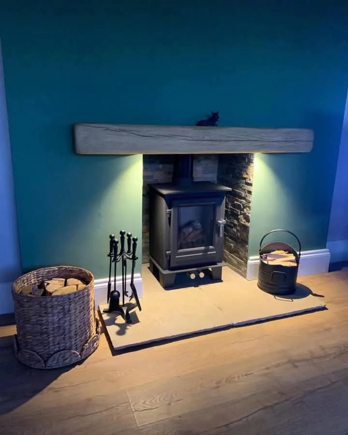 Wood burner with a grey beam and lit chamber